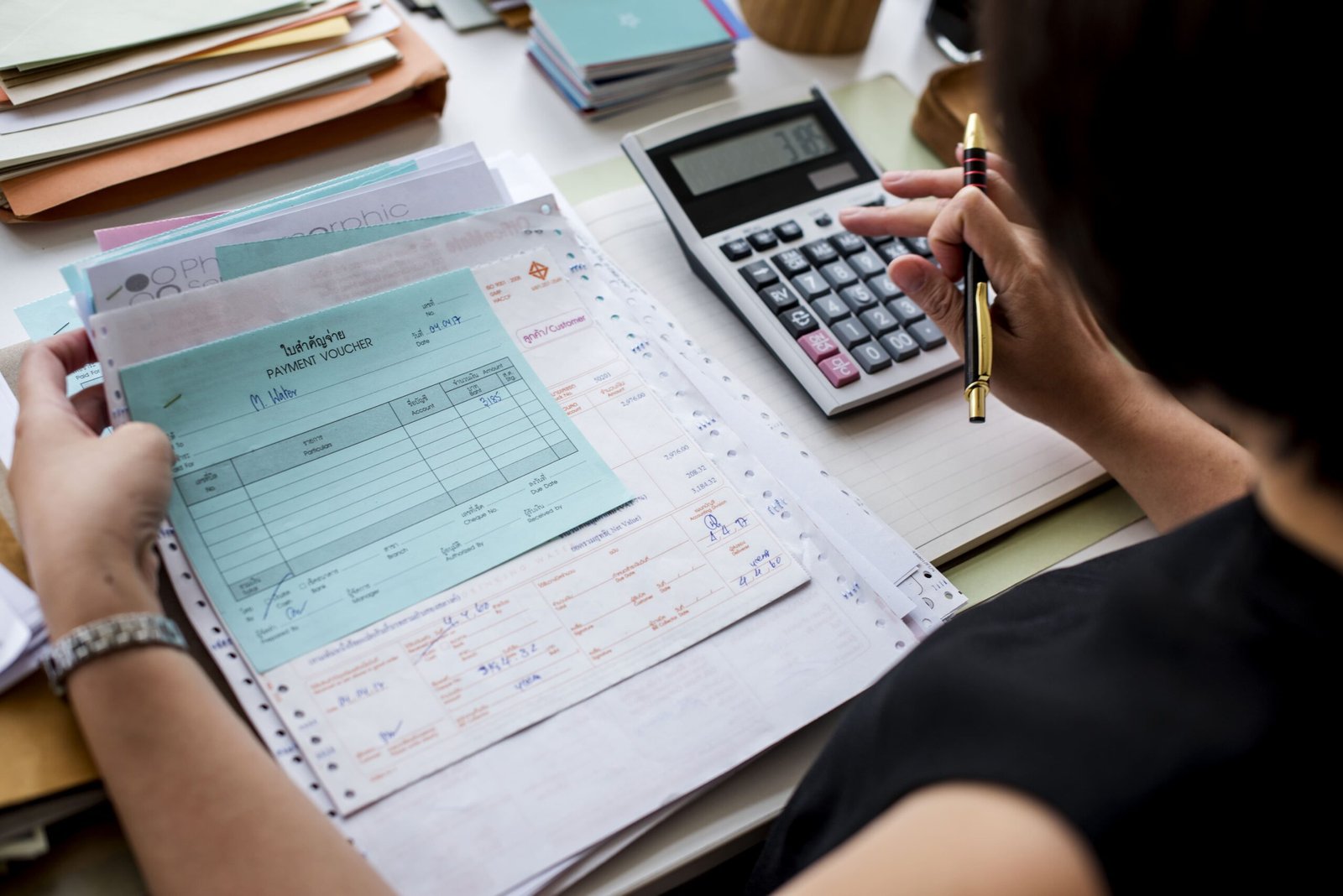 Personal tax forms, calculator, and receipts on a table, symbolizing organized and stress-free tax filing with Wio Accounting.