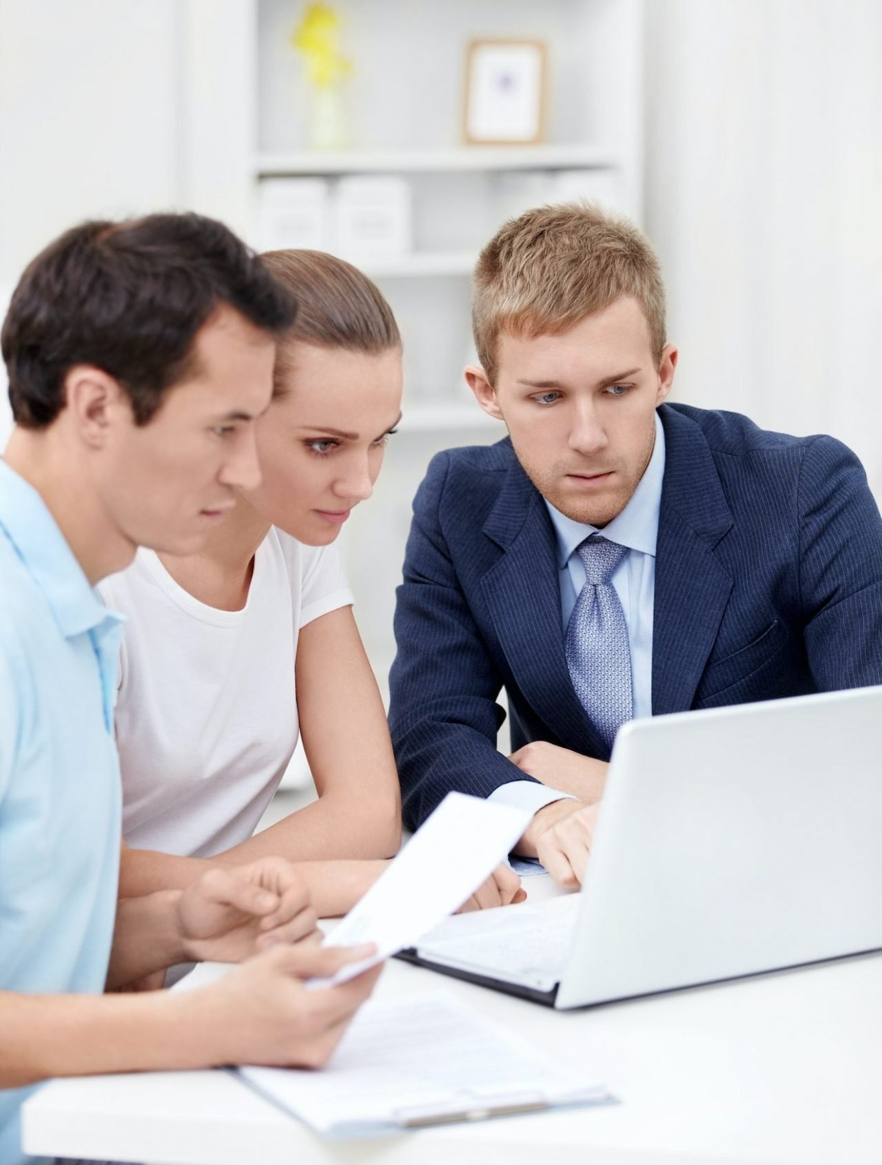 Three professionals discussing tax services while reviewing information on a computer – collaborative tax planning and accounting support