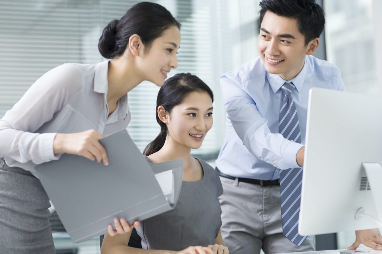 Young business professionals using a computer in a modern office – collaborative financial planning and accounting support
